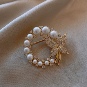 Broche circulaire dorée de perles